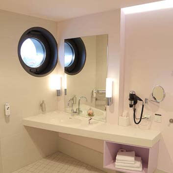 White modern bathroom with a Corian vanity cabinet featuring a seamless sink