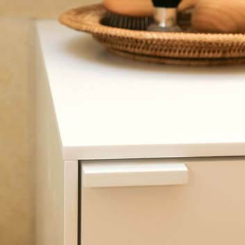 White cabinet consisting of thin sides and a small cubic white handle at the upper corner