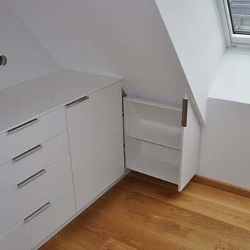 Built-in kitchen under sloping ceiling, angled pull-out cabinet.