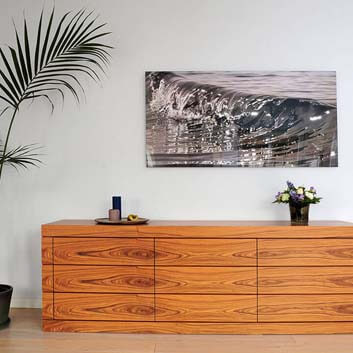 A beautifully veneered sideboard with a repeating wood texture on 3 drawer levels, image of a water flow on top