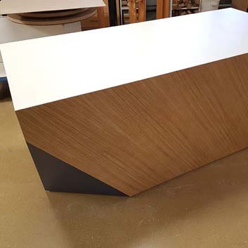 Counter, a rectangular block with differently colored and textured HPL, with 3 cut corners