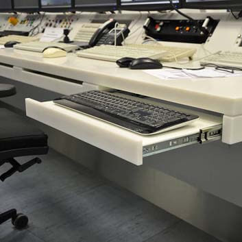 Custom-made furniture for an operating room in a technical facility, Corian desk with retractable keyboard trays.