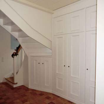 Complete built-in cabinets under the stairs in traditional style