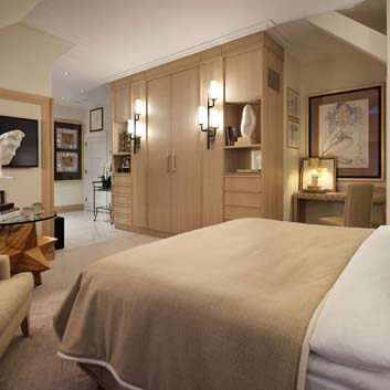 Luxurious boutique hotel room, custom-made wardrobe in brushed white oak, with original wooden form coffee table.