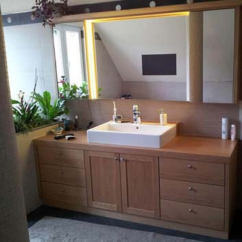 Modernes klassisches Badezimmer mit einem hölzernen Waschtisch mit Türen und Schubladen und einem weißen Keramikwaschbecken
