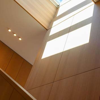 Modernes, beruhigendes Interieur, holzverkleidete Wände und ein Treppengeländer aus Holz.
