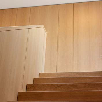 Modernes, beruhigendes Interieur, gerade Linien, verkleidete Wände, versteckte Türen, Holztreppe